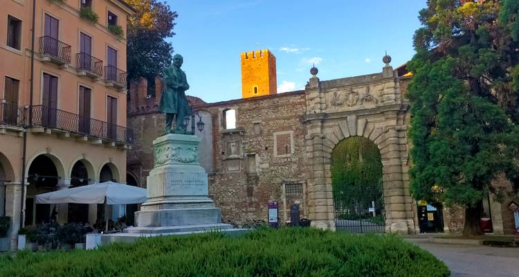 Historische Statue auf einem Stadtplatz mit alten Gebäuden.
