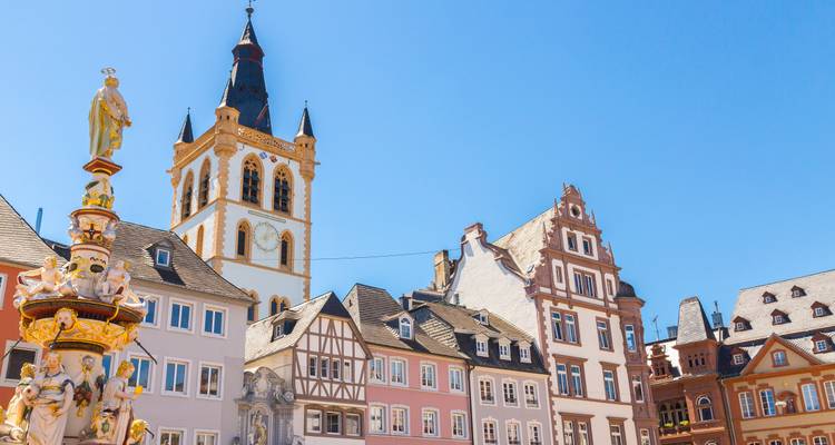 Bâtiments historiques et une église sur une place de vieille ville européenne.