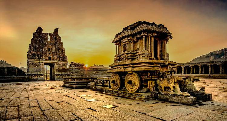 Oude stenen strijdwagen in de ruïnes van Hampi, India, tijdens een gouden zonsondergang.