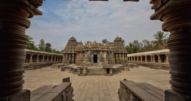 Een tempelplein met ingewikkelde stenen structuren en zuilengalerijen.