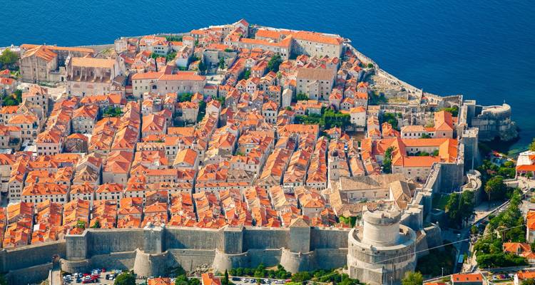 Vue aérienne d'une ville historique fortifiée au bord de la mer.
