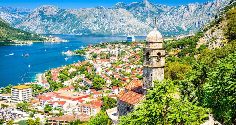 Baie de montagne avec une église historique et une ville animée.
