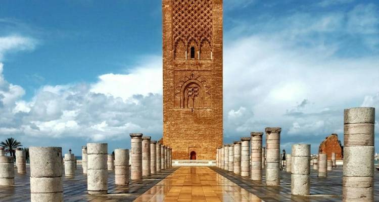 Torre histórica con columnas de piedra bajo un cielo azul en Rabat, Marruecos.