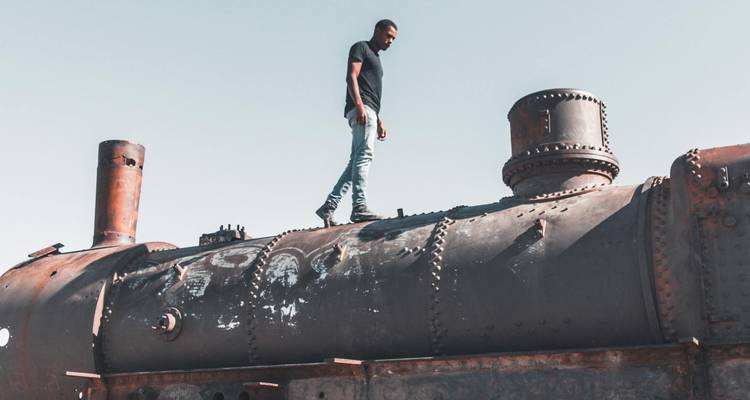 Une personne debout sur une ancienne locomotive.