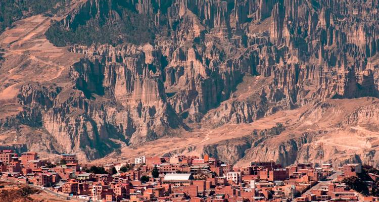 Une ville avec des falaises rocheuses en arrière-plan.