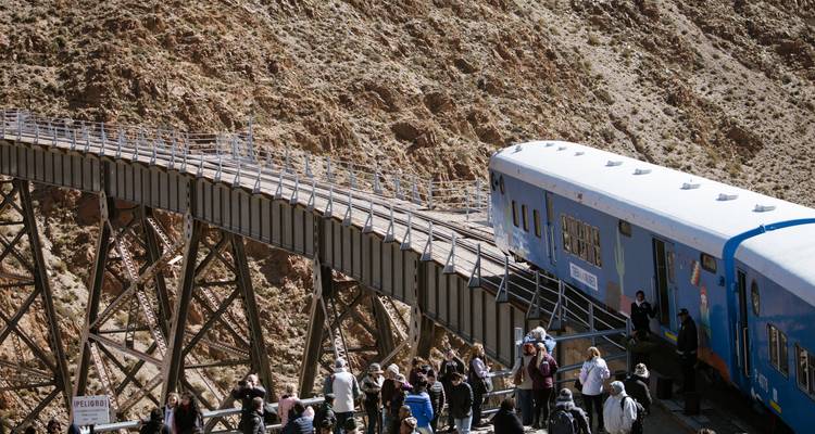 Des personnes explorant sur un pont à côté d'un train pittoresque.