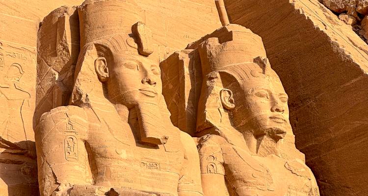 Nahaufnahme der kolossalen Sandsteinstatuen von Ramses II., die in die Felswand von Abu Simbel gemeißelt sind.