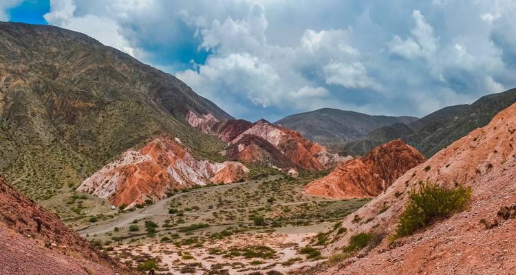 Formations rocheuses colorées dans un paysage désertique sous un ciel bleu.