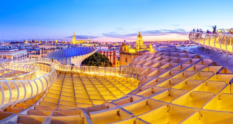 Estructura arquitectónica moderna con vista panorámica de la ciudad al atardecer.