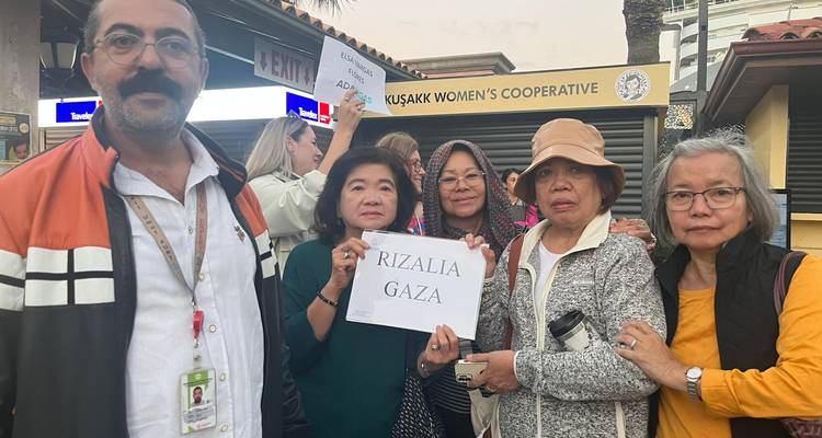 Grupo de personas posando con carteles frente a una cooperativa.