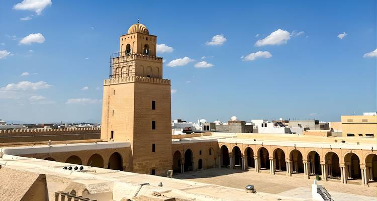 Minaret et cour dans un lieu historique sous un ciel dégagé.