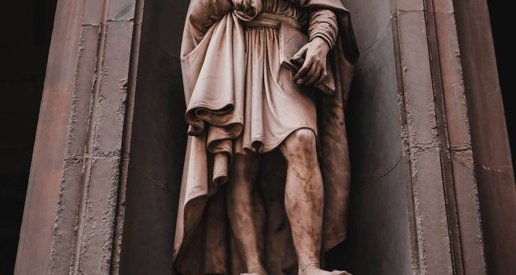 Close-up of a Renaissance marble statue framed by shadowed columns