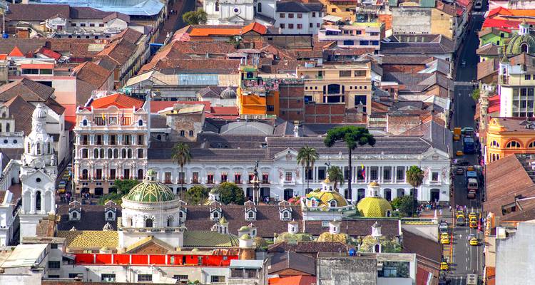 Luftaufnahme des historischen Quito mit bunten Dächern und Kirchen.