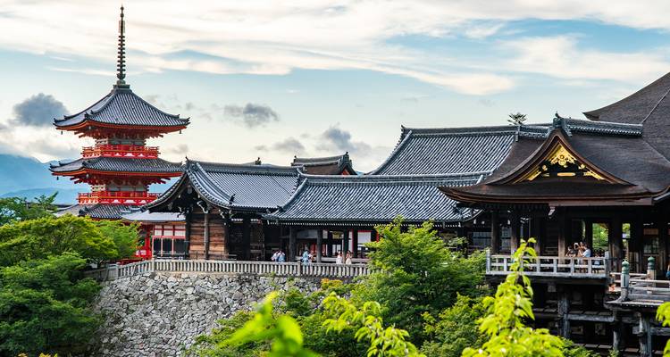 Templo japonés tradicional con pagoda en un entorno exuberante.