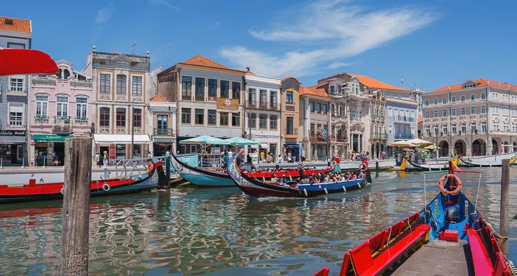 Góndolas coloridas en los canales de Aveiro con edificios históricos.