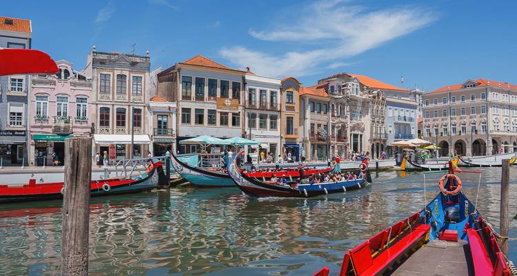 Traditionele kleurrijke gondel-achtige bootjes op het kanaal in Aveiro omgeven door pastelkleurige gebouwen