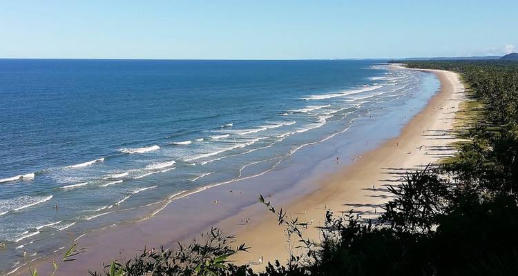 Vista expansiva de una playa arenosa con olas del océano.