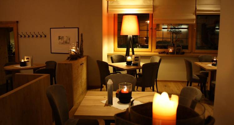 Comedor con velas, asientos acogedores e iluminación suave.
