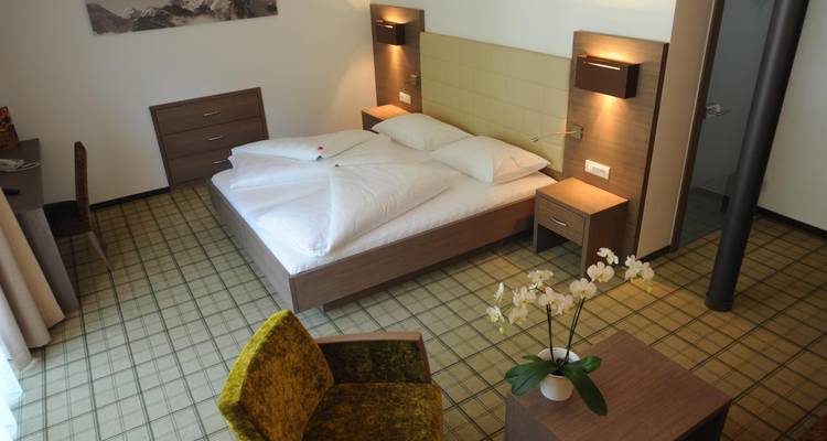 Habitación de hotel minimalista con mobiliario moderno y vistas al jardín.