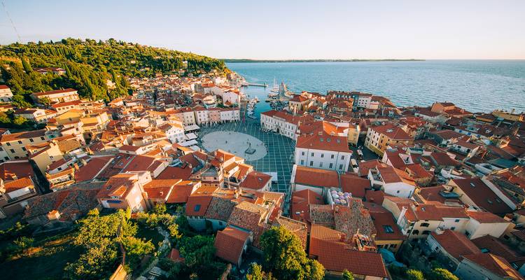 Vista aérea de un pueblo costero con edificios coloridos y un puerto deportivo.