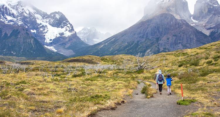Famille en randonnée sur un sentier pittoresque avec des montagnes rocheuses.