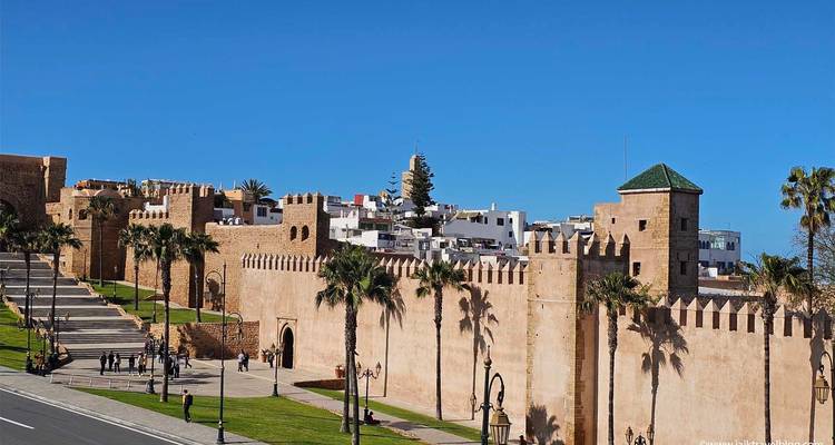 Eine befestigte Mauer mit Menschen, die in der Nähe in einer Stadtlandschaft spazieren gehen.