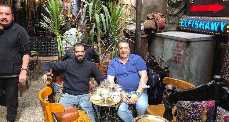 Disposición de asientos informal en un mercado o restaurante con dos hombres sentados.