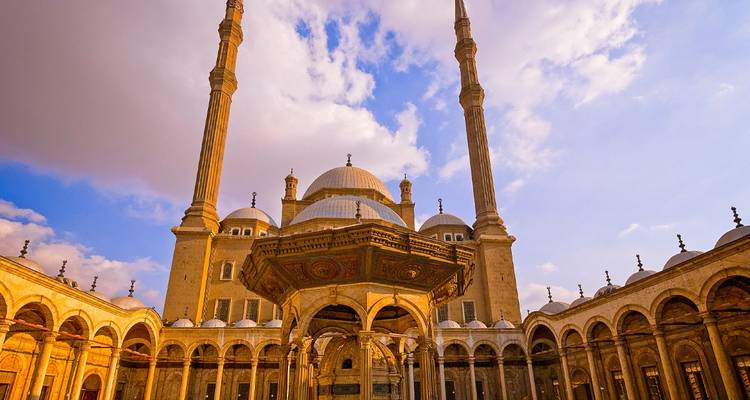 Majestuosa mezquita con minaretes gemelos y una gran cúpula al atardecer.