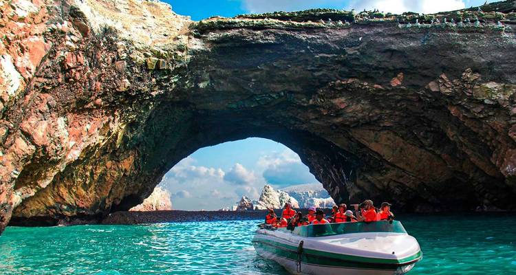 Boot met toeristen die door een natuurlijke boog op zee vaart.