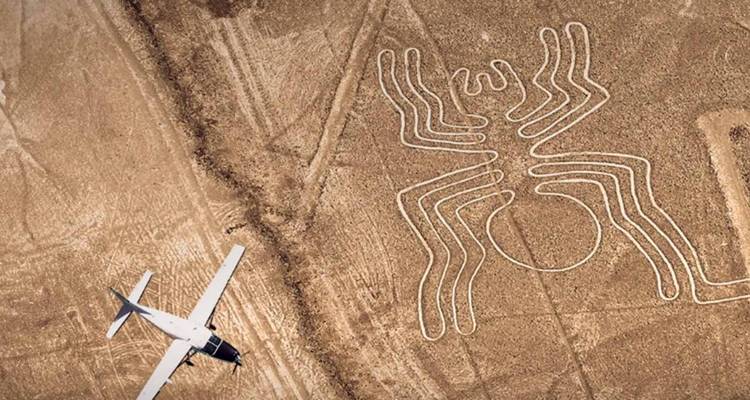 Vue aérienne des lignes de Nazca avec un petit avion à proximité.