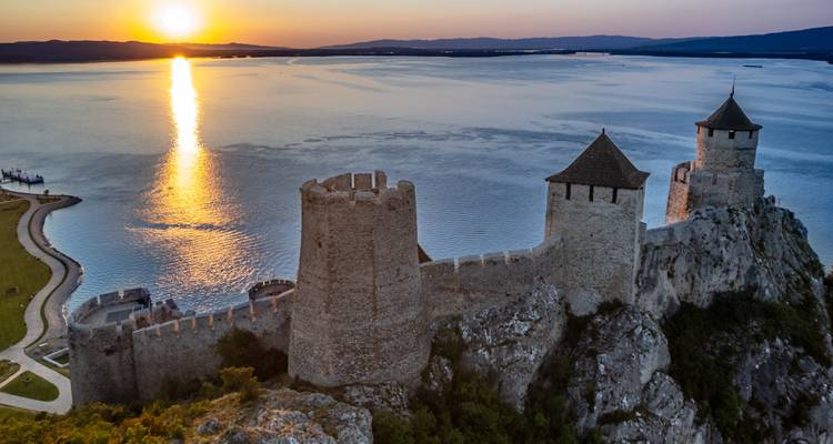 Fortaleza medieval de Golubac encaramada en acantilados sobre el Danubio al ardiente atardecer.