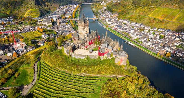 Perspective aérienne de la forteresse Reichsburg Cochem surplombant les vignobles et le méandre de la rivière Moselle.