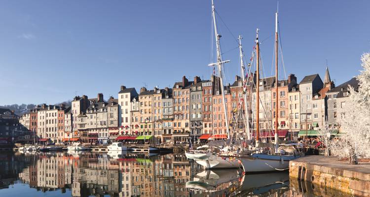 Hochmastige Boote reihen sich entlang der farbenfrohen Hafengebäude aus dem 17. Jahrhundert in Honfleur.