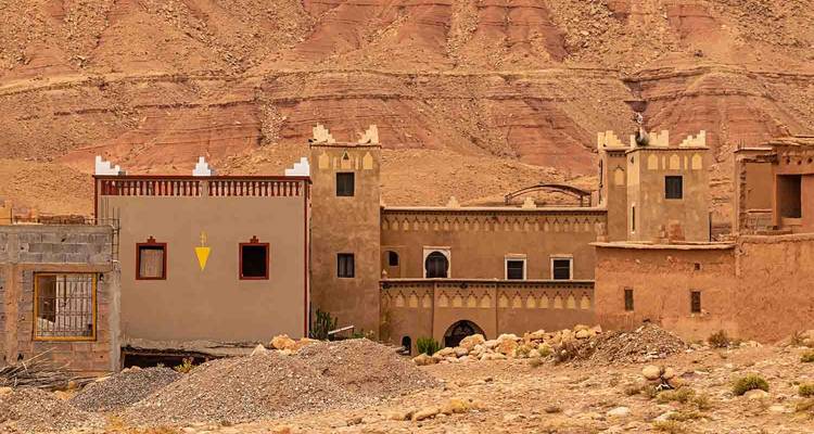 Façade de bâtiment traditionnel marocain sur un fond rocheux.