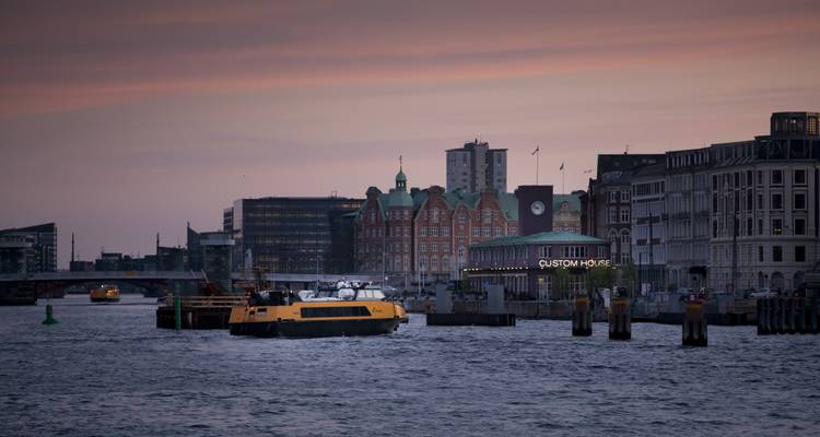 Una escena portuaria con barcos contra un cielo de atardecer.