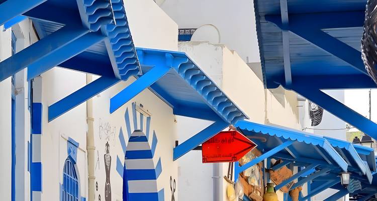 Bunt gefärbte Markisen erstrecken sich über eine Straße, die von malerischen Boutiquen gesäumt ist.