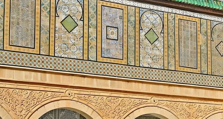 Nahaufnahme einer verzierten gefliesten Wand mit geometrischen Mustern.