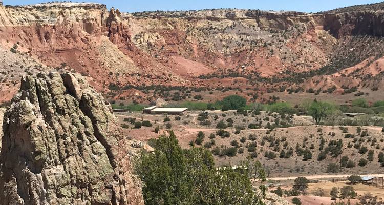 Una vista panorámica de un paisaje desértico con formaciones rocosas rojas y vegetación.