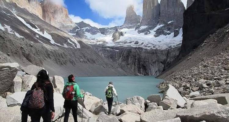 Trekkers naderen de turquoise lagune onder torenhoge granieten spitsen in Torres del Paine