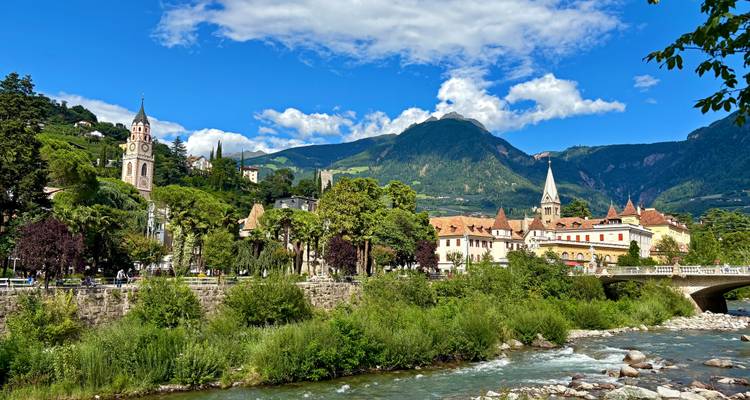 A charming town with historic buildings set against a lush mountain backdrop.