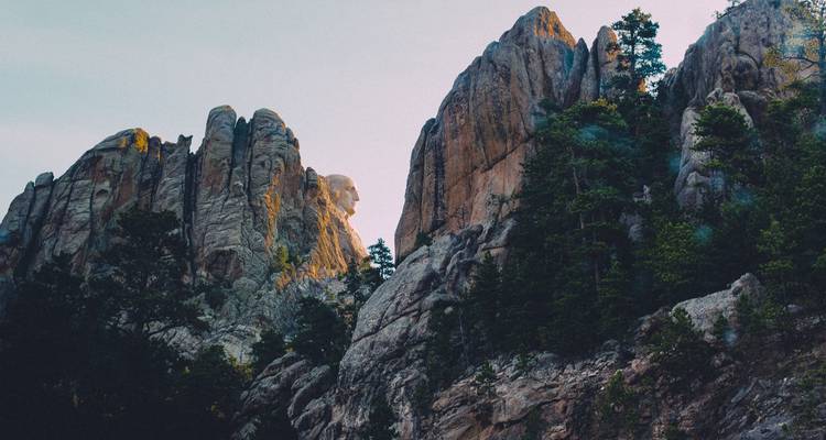 Mount Rushmore mit malerischem Laub im Vordergrund.