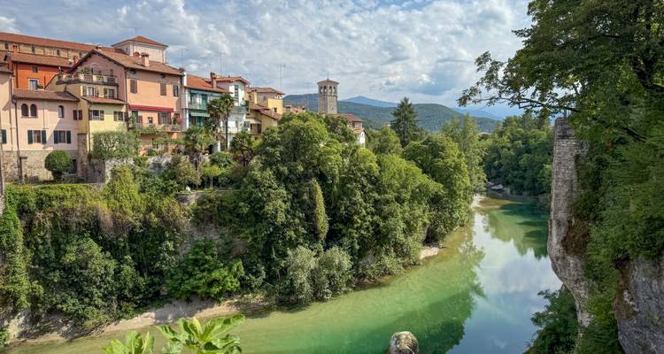 Luftaufnahme einer malerischen Stadt an einem Fluss mit üppigem Grün und Brücken.