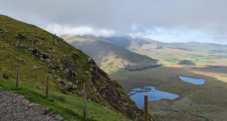 Misty mountain slope descending to a remote valley dotted with small lakes