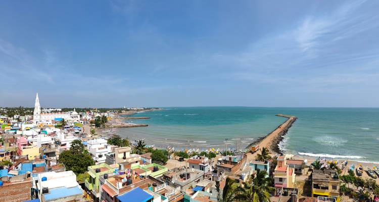 Ville côtière avec des maisons colorées et une longue jetée.