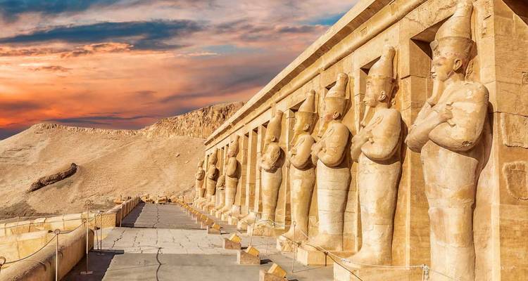 Estatuas del antiguo Egipto bajo la luz dorada del atardecer.