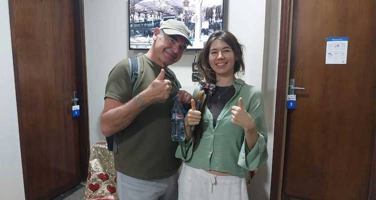 Dos personas dando pulgares arriba en un pasillo de hotel.