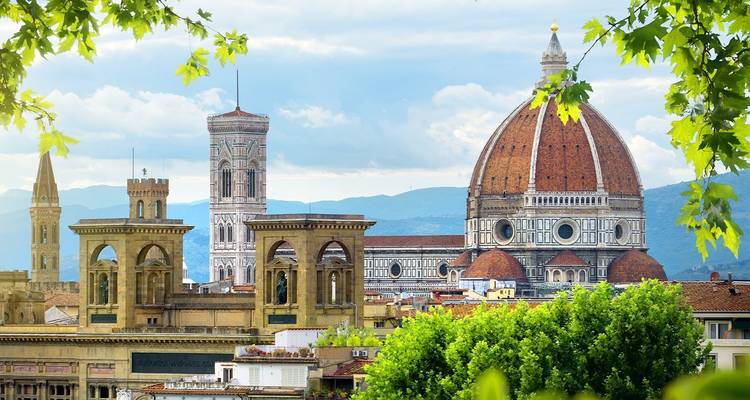 Florenz Skyline mit der roten Ziegeldachkuppel des Doms von Santa Maria del Fiore, umrahmt von frischem Frühjahrslaub.
