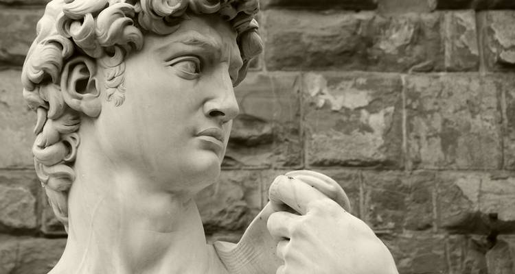 Nahaufnahme in Sepia des David von Michelangelo, die den lebensechten Gesichtsausdruck hervorhebt.