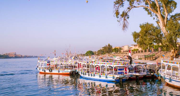 Barcos coloridos atracados a lo largo de la ribera con un matiz de atardecer.