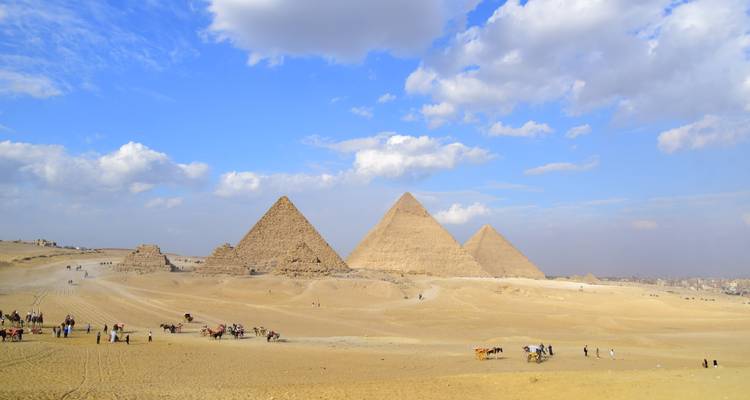 Weite Ansicht der Pyramiden von Gizeh in einer Wüstenlandschaft.